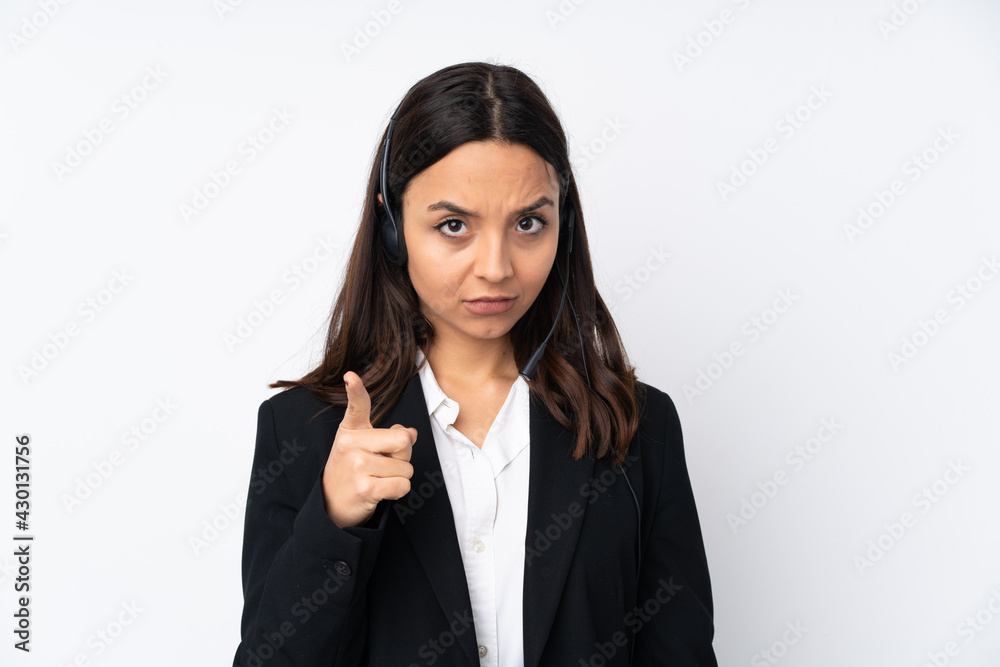 Young telemarketer woman isolated on white background frustrated and pointing to the front Young telemarketer woman isolated on white background frustrated and pointing to the front