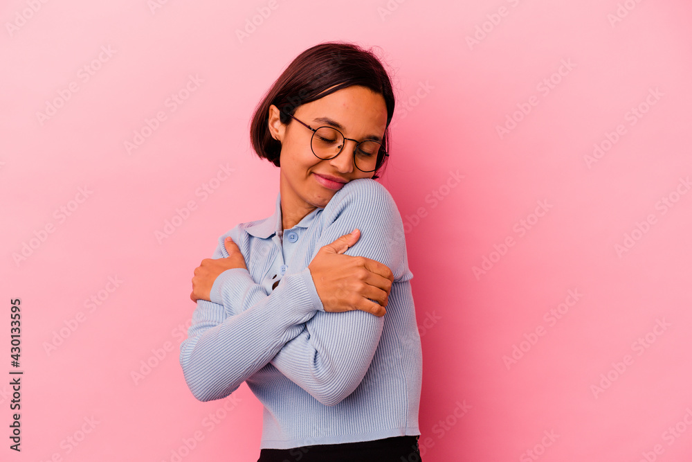 Young mixed race woman isolated on pink background hugs, smiling carefree and happy. Young mixed race woman isolated on pink background hugs, smiling carefree and happy.