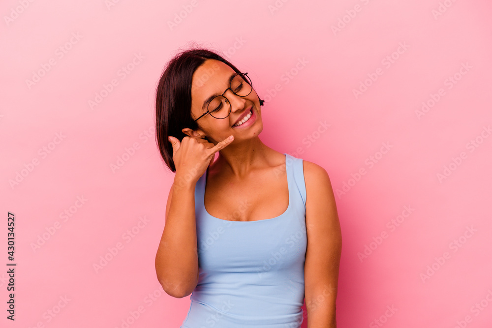 Young mixed race woman isolated on pink background showing a mobile phone call gesture with fingers. Young mixed race woman isolated on pink background showing a mobile phone call gesture with fingers.