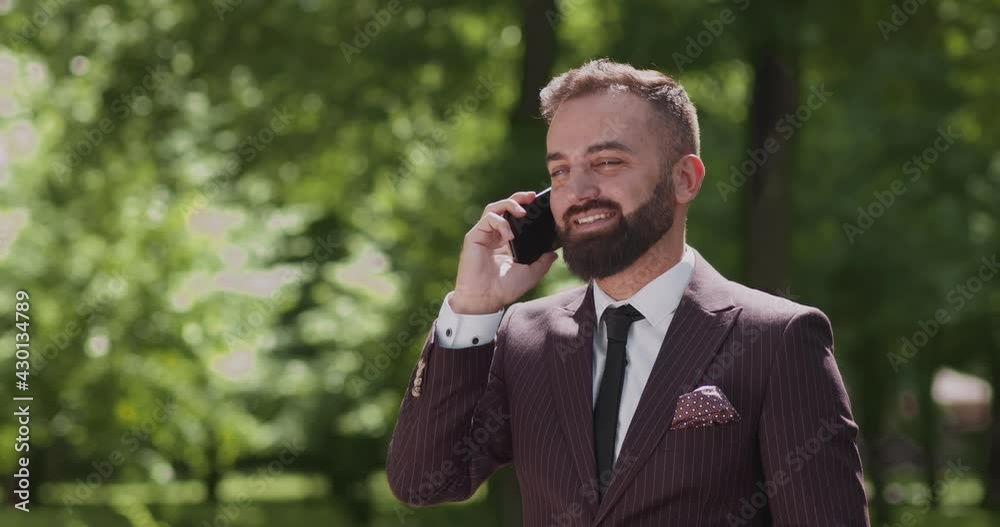 Always In Touch. Successful businessman in talking on smartphone, standing in urban park, free space Always In Touch. Successful businessman in talking on smartphone, standing in urban park, free space