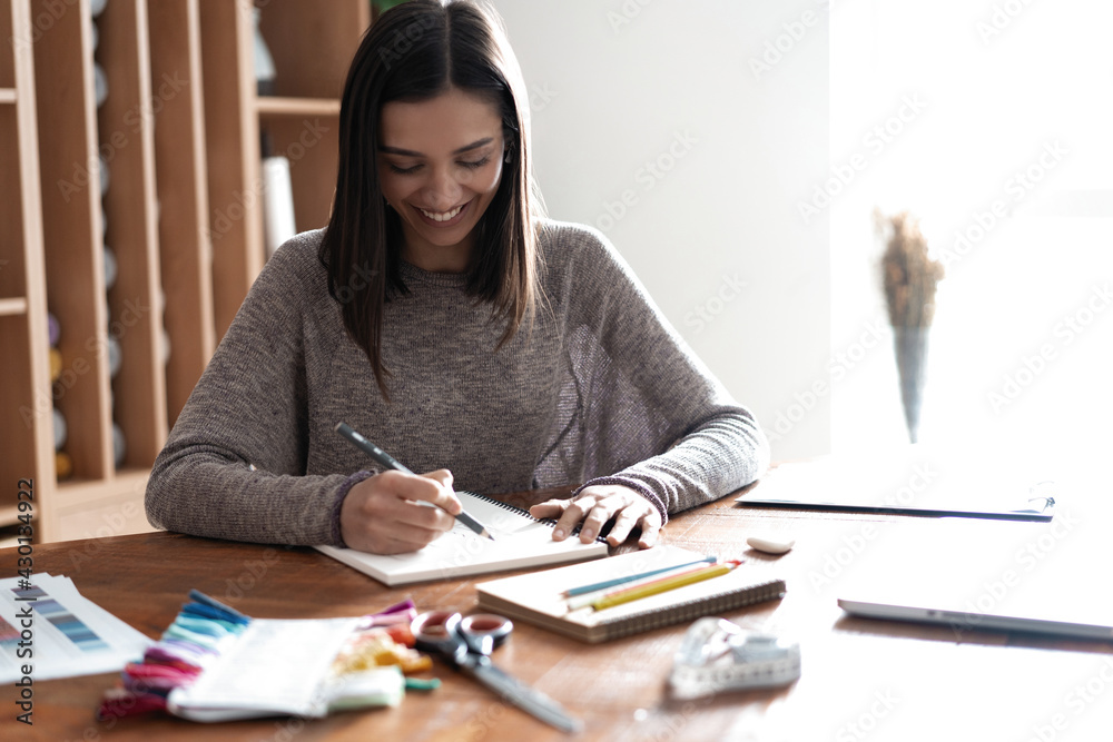 Indian mixed-race pretty designer working at her desk in her office. Indian mixed-race pretty designer working at her desk in her office.