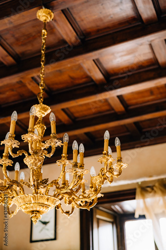 Close-up of an antique gold chandelier in the interior of an old villa.