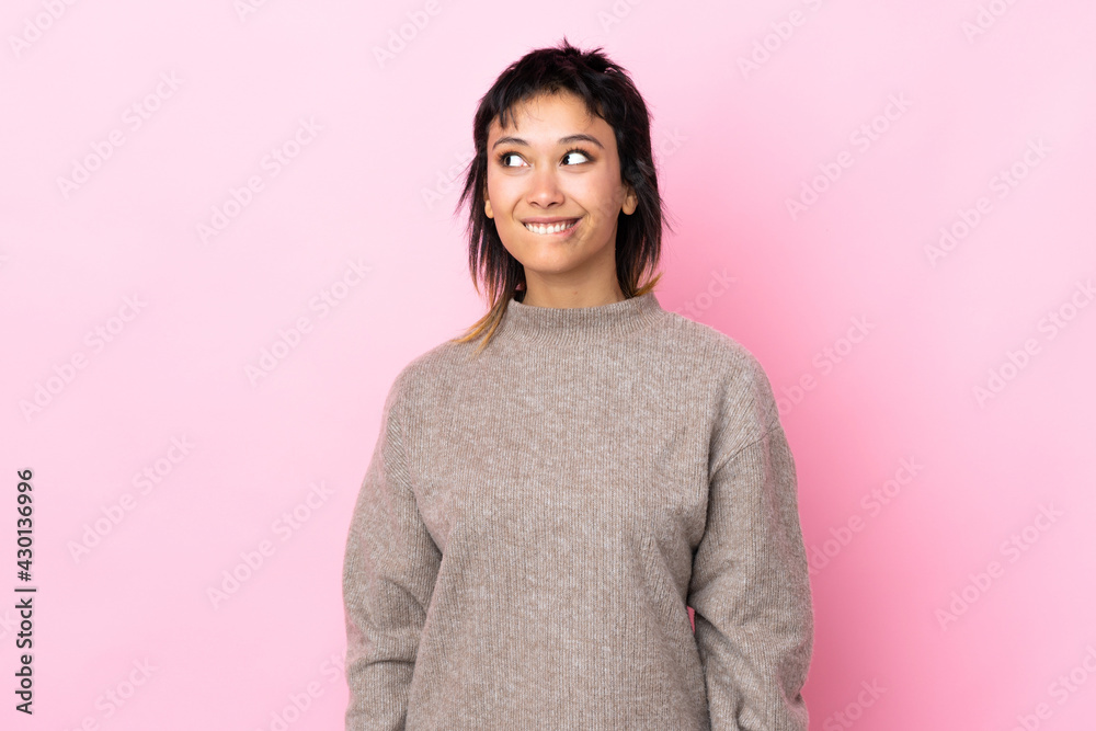 Young Uruguayan woman over isolated pink background having doubts while looking up Young Uruguayan woman over isolated pink background having doubts while looking up