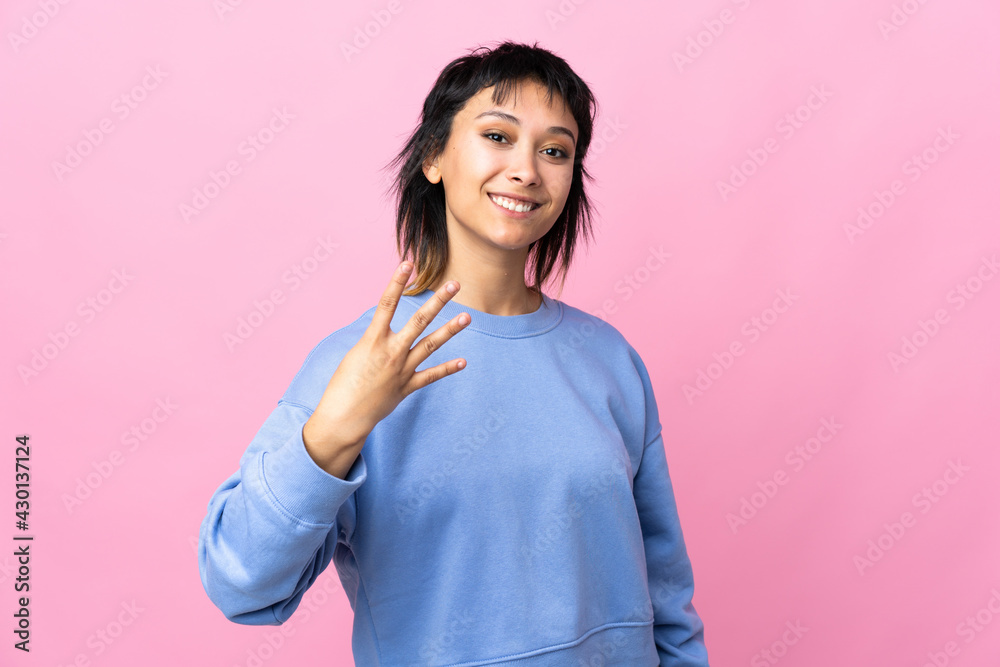 Young Uruguayan woman over isolated pink background happy and counting four with fingers Young Uruguayan woman over isolated pink background happy and counting four with fingers