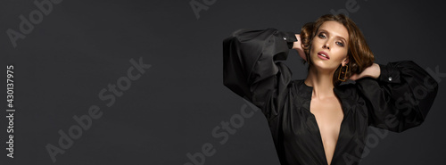 Portrait of beautiful brunette woman in black dress. Fashion photo