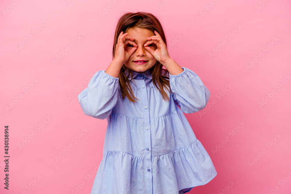 Little caucasian girl isolated on pink background showing okay sign over eyes Little caucasian girl isolated on pink background showing okay sign over eyes