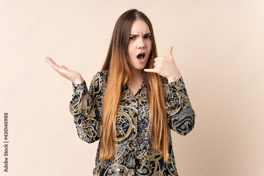 Young caucasian woman isolated on beige background making phone gesture and doubting Young caucasian woman isolated on beige background making phone gesture and doubting