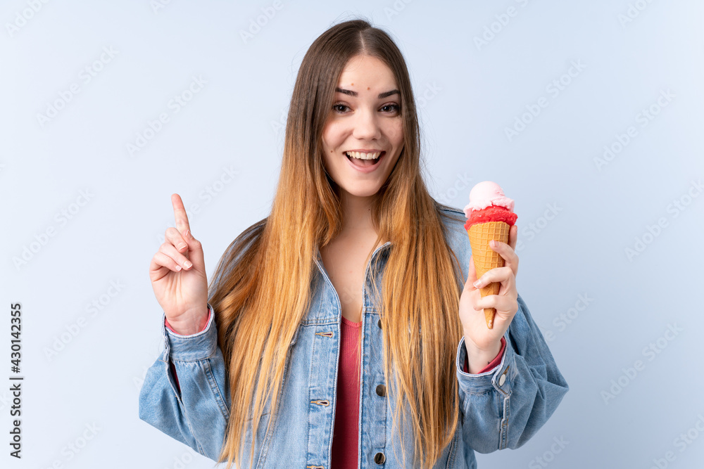 Young woman with a cornet ice cream isolated on blue background pointing up a great idea Young woman with a cornet ice cream isolated on blue background pointing up a great idea