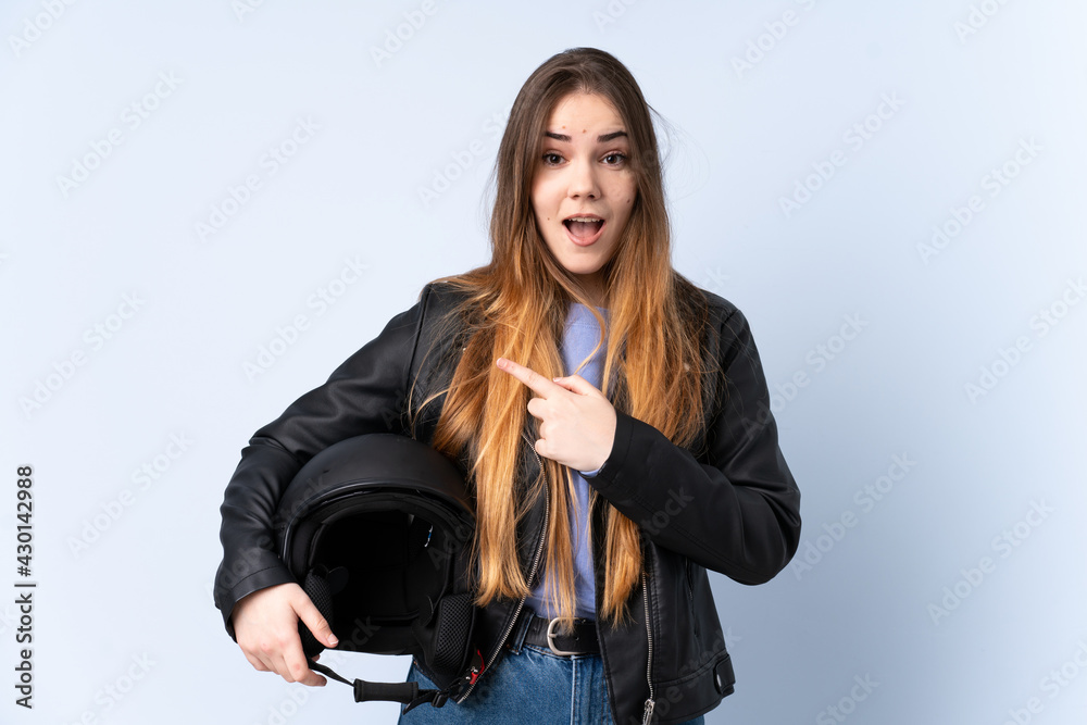 Woman with a motorcycle helmet pointing finger to the side Woman with a motorcycle helmet pointing finger to the side