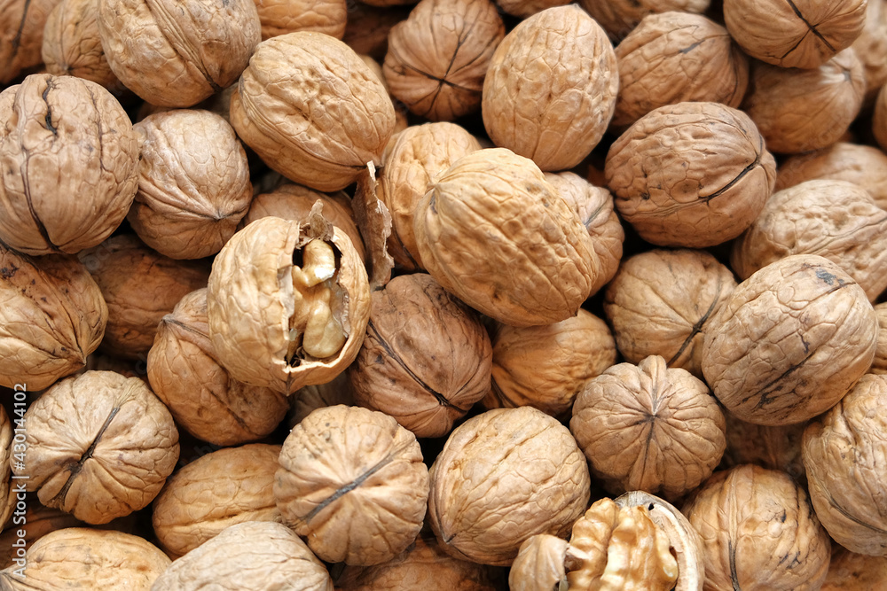 Walnut kernels and whole walnuts on rustic old wooden table Walnut kernels and whole walnuts on rustic old wooden table