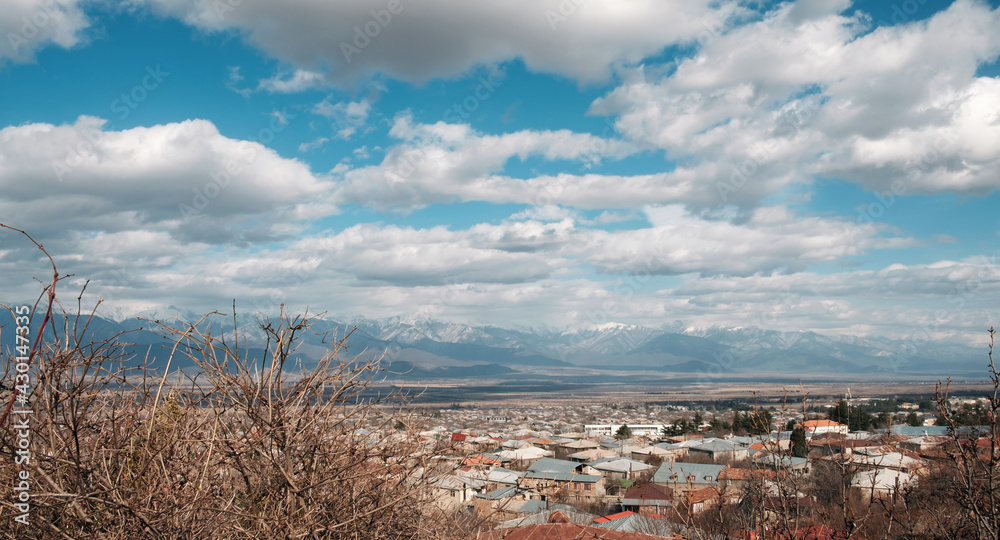 Beautiful view of Caucasus mountains and cloudy sky from the town