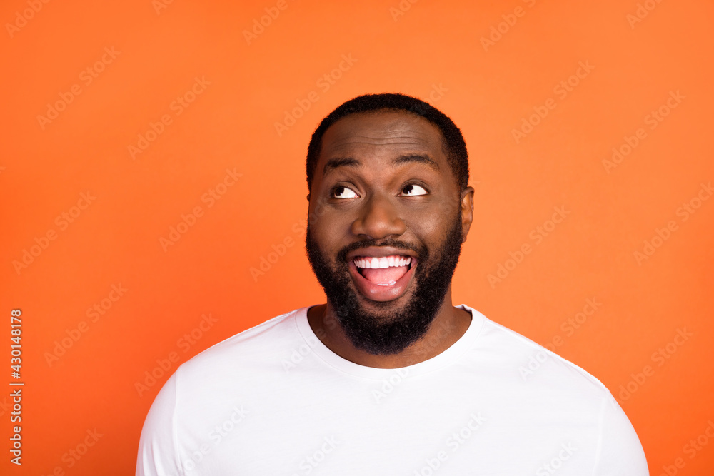 Photo of amazed happy positive young afro american man look empty space good mood isolated on orange color background Photo of amazed happy positive young afro american man look empty space good mood isolated on orange color background