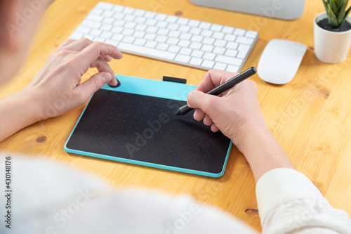 Hand of graphic designer working with stilus and tablet