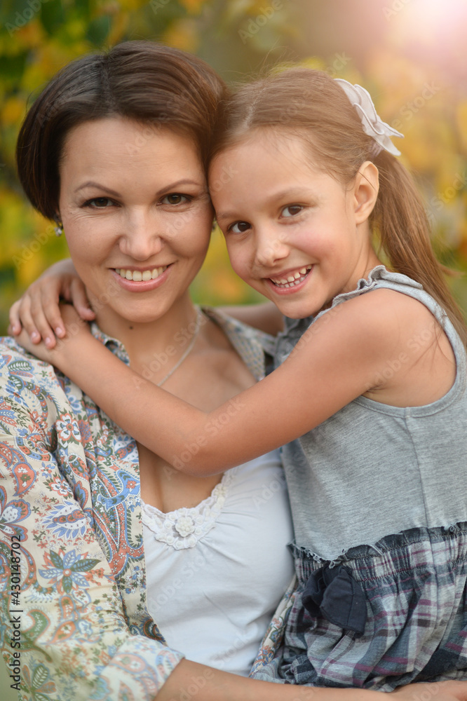 Portrait of happy mother and daughter smiling outdoors