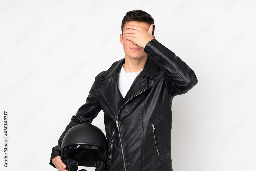 Man holding a motorcycle helmet isolated on white background covering eyes by hands Man holding a motorcycle helmet isolated on white background covering eyes by hands