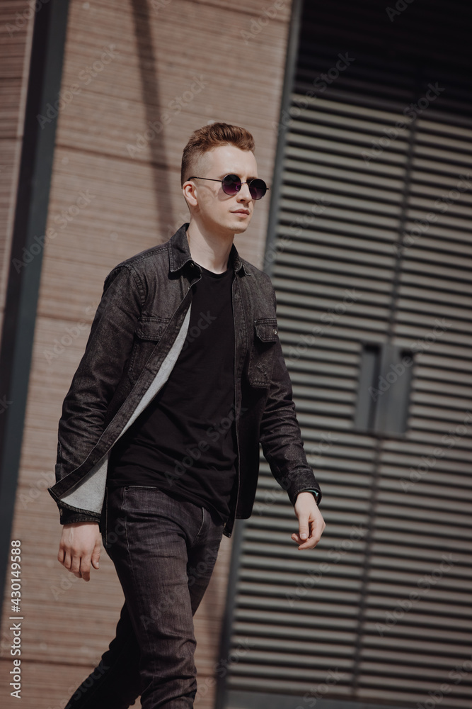 Young fashion man walking in a city street