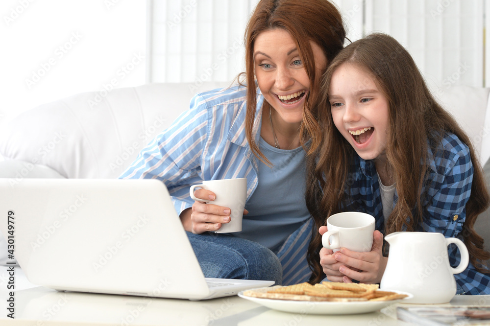 Portrait of smiling mother and daughter with laptop at home Portrait of smiling mother and daughter with laptop at home
