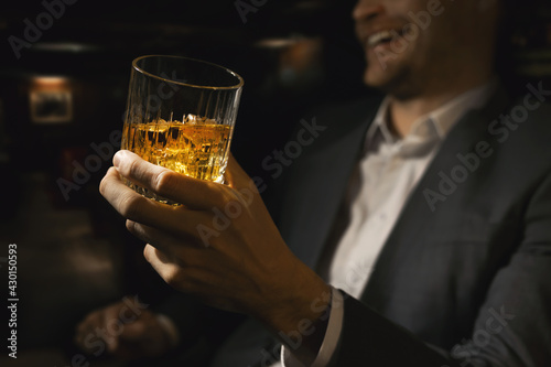 happy businessman with glass of whiskey in gentlemen club bar