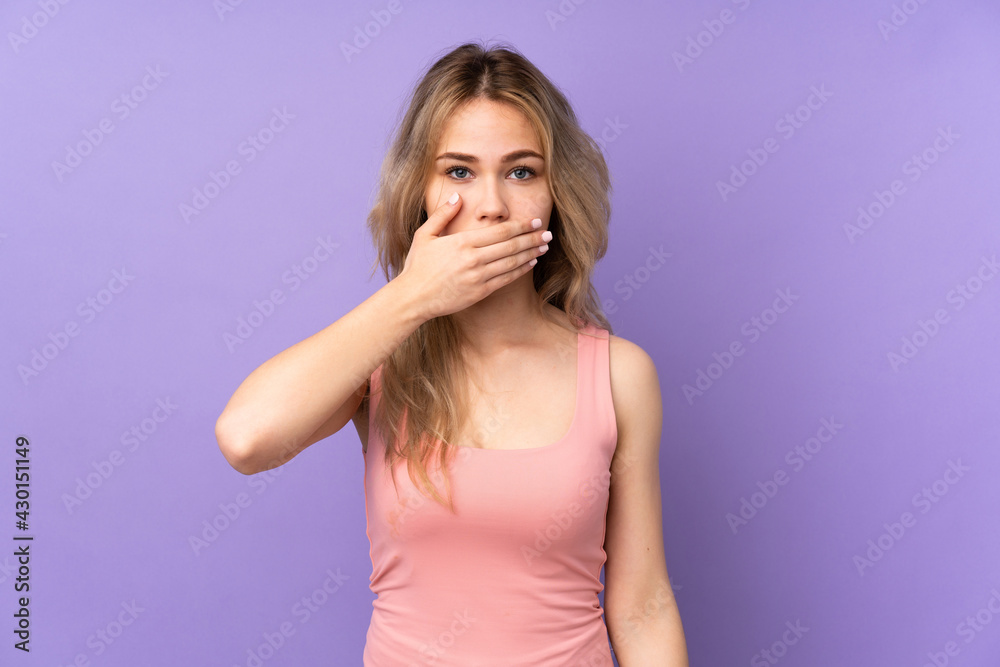 Teenager Russian girl isolated on purple background covering mouth with hands