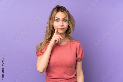 Teenager Russian girl isolated on purple background and looking front