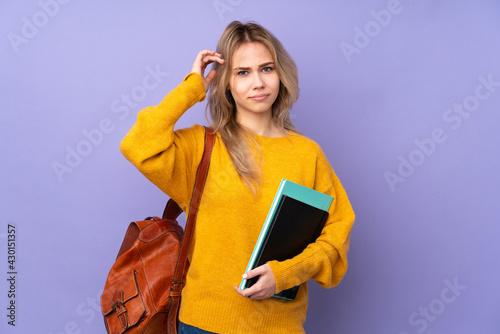 Teenager Russian student girl isolated on purple background having doubts