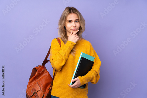 Teenager Russian student girl isolated on purple background thinking