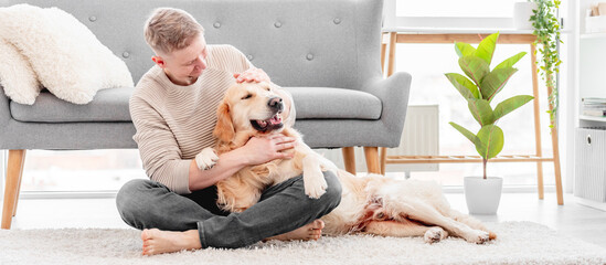 Man sitting with golden retriever dog