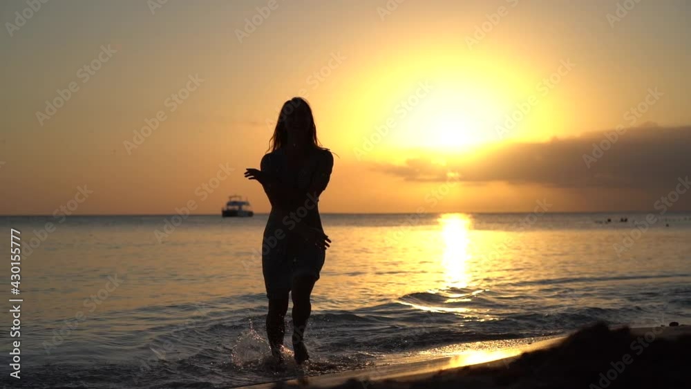 Carefree and happy woman jumping and getting fun during sunset at the seascape. concept of healthy lifestyle and happiness Carefree and happy woman jumping and getting fun during sunset at the seascape. concept of healthy lifestyle and happiness