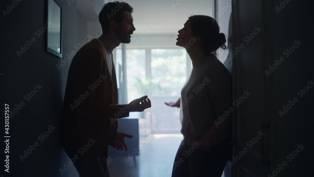 Young Couple Arguing and Fighting. Domestic Violence and Emotional abuse Scene, Stressed Woman and aggressive Man Screaming at Each other in the Dark Hallway of Apartment. Dramatic Scene