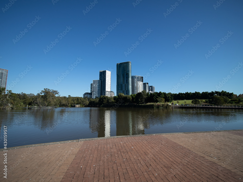 Panoramic view of a colourful green park in Sydney with a large pond and apartment towers in the background NSW Australia