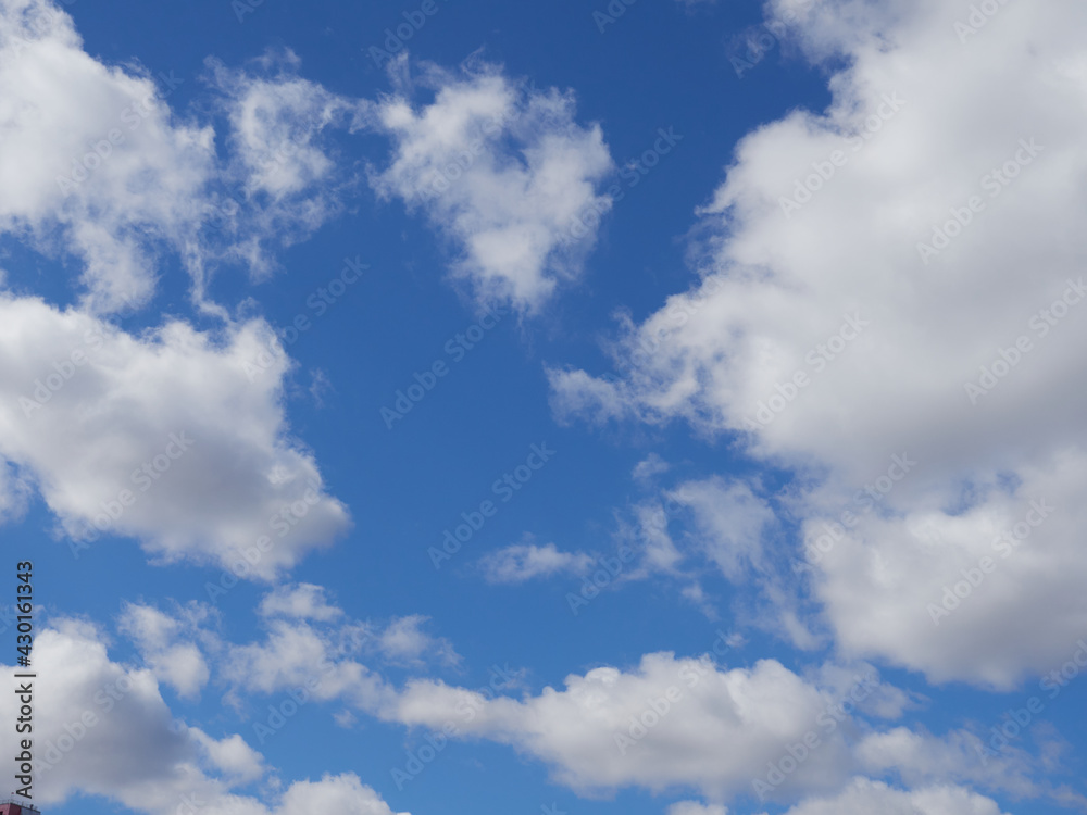 Fototapeta premium Natural sunny blue sky background with beautiful lush white cumulus clouds and fluffy cirrus clouds