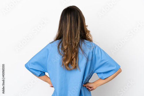 Young surgeon doctor woman over isolated white wall in back position