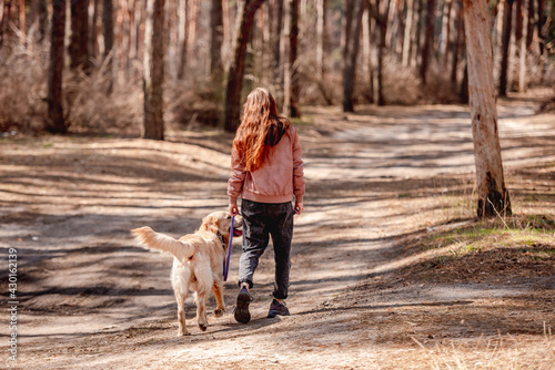 Girl with golden retriever dog in the wood