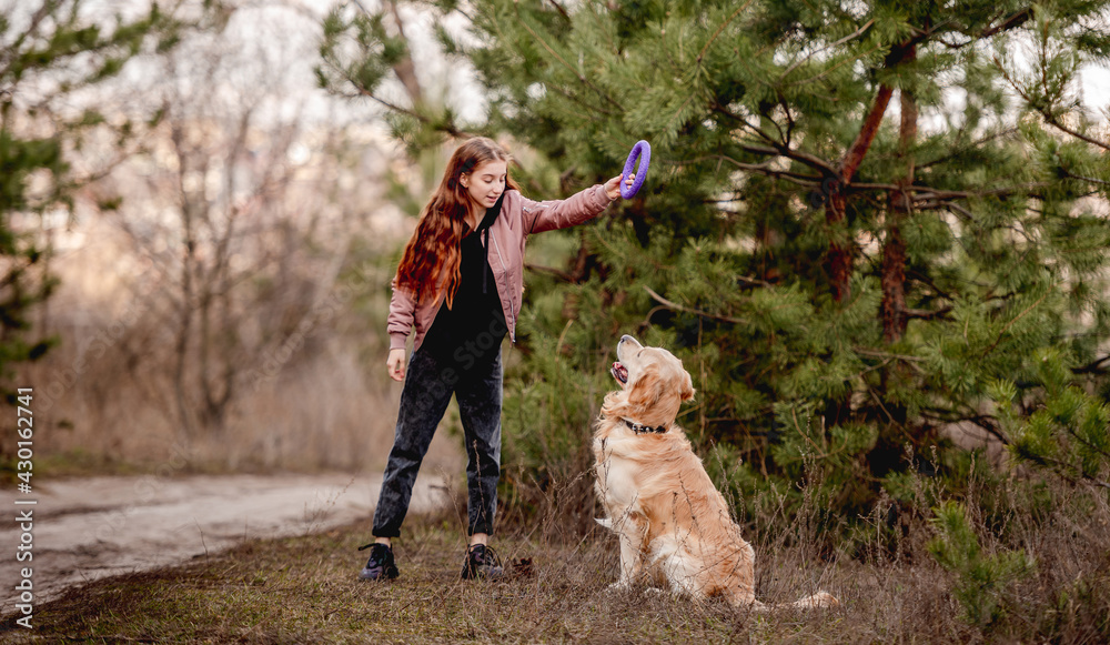 Girl with golden retriever dog in the wood Girl with golden retriever dog in the wood