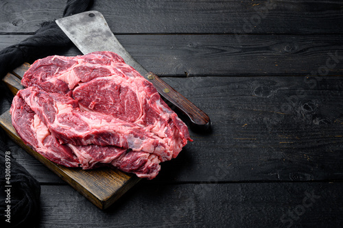 Raw fresh organic top choice meat ribeye steak, on black wooden table background, with copy space for text