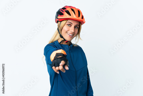 Young blonde Uruguayan cyclist woman isolated on background pointing front with happy expression