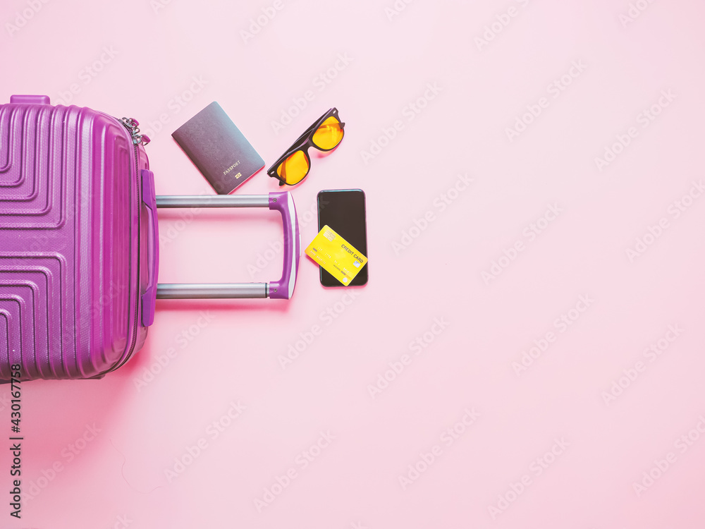 Obraz premium summer travel concept from credit card and suitcase with summer collection on pink background.