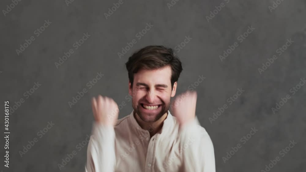 The happy man rejoicing at the victory and saying yes while jumping up and down in the studio The happy man rejoicing at the victory and saying yes while jumping up and down in the studio