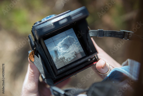 An overhead view of hands holding a medium format retro film camera. Close-up photo