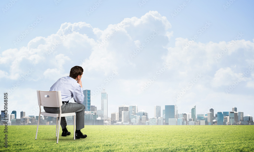 Young businessman sitting on an office chair Young businessman sitting on an office chair