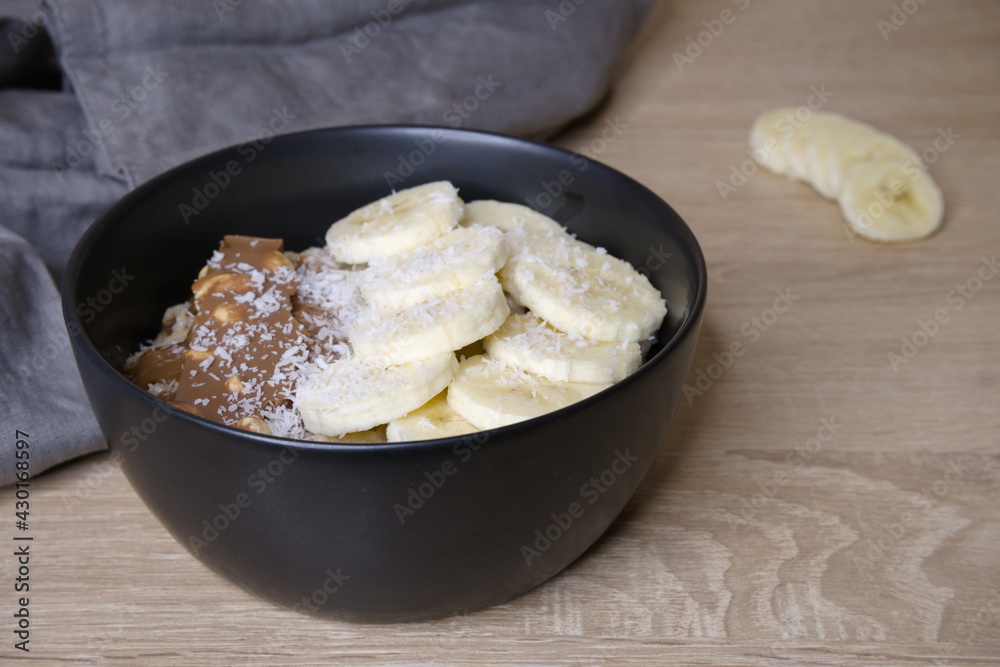 Oatmeal with banana. Oatmeal in a black plate. Cooking. Food. Oatmeal with banana. Oatmeal in a black plate. Cooking. Food.