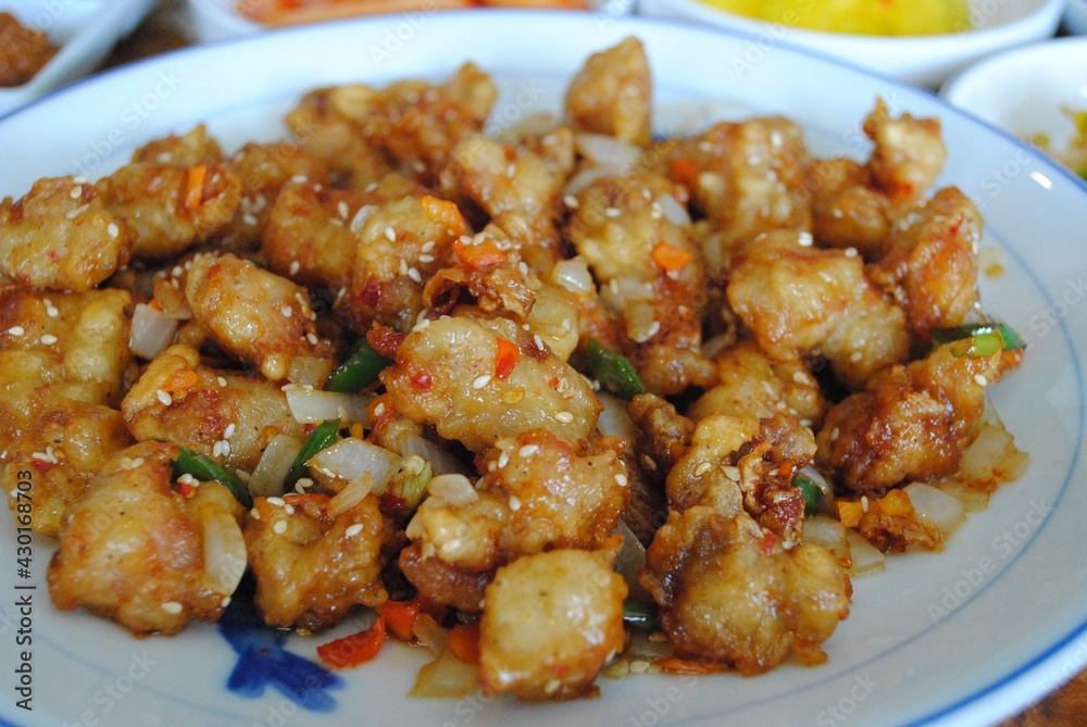 Close up of fried chicken bites with red hot peppers Close up of fried chicken bites with red hot peppers