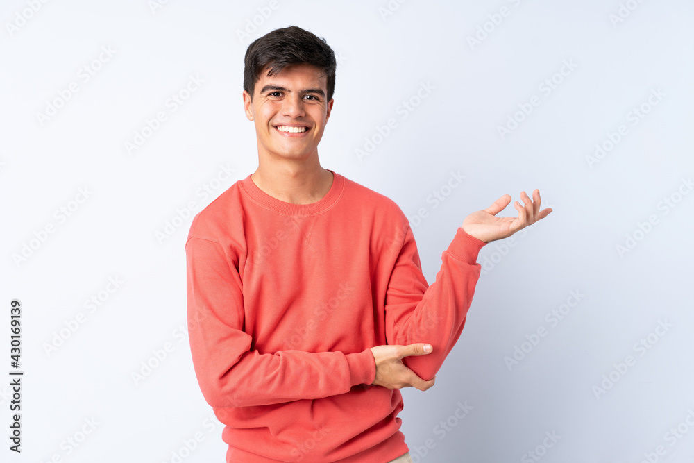 Handsome man over isolated blue background pointing finger to the side Handsome man over isolated blue background pointing finger to the side