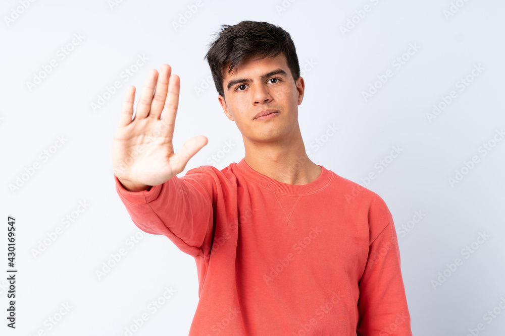 Handsome man over isolated blue background making stop gesture Handsome man over isolated blue background making stop gesture