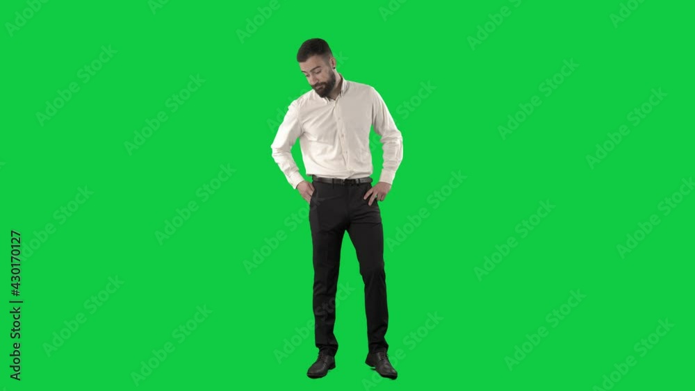Nervous bored business man standing and waiting checking time on phone. Full length on green screen chroma key background Nervous bored business man standing and waiting checking time on phone. Full length on green screen chroma key background