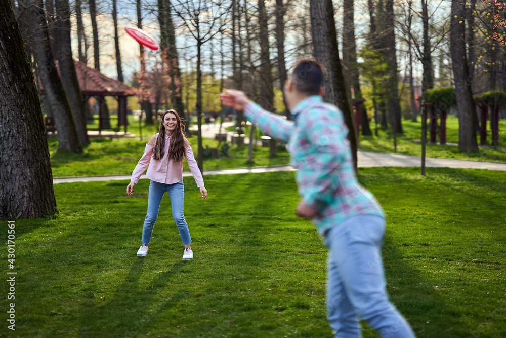 Obraz premium Young couple playing freesbie in the park