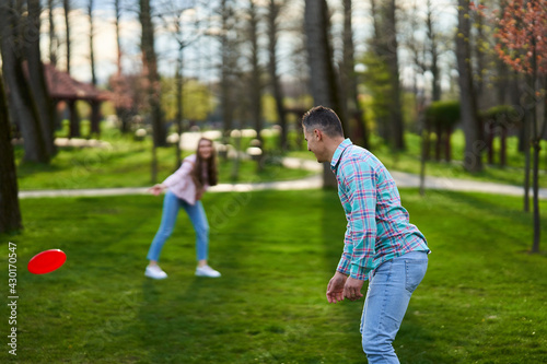Young couple playing freesbie in the park