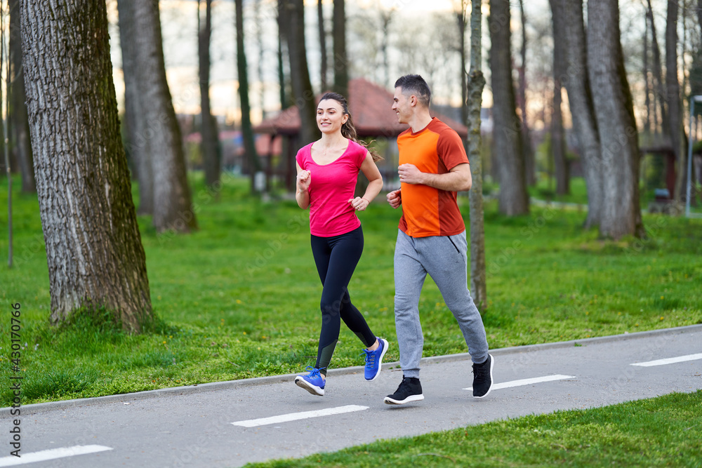 Fototapeta premium Young couple running in the park