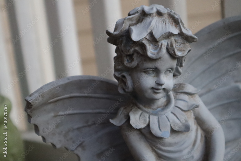 Angle stone statue close up face on front porch Angle stone statue close up face on front porch
