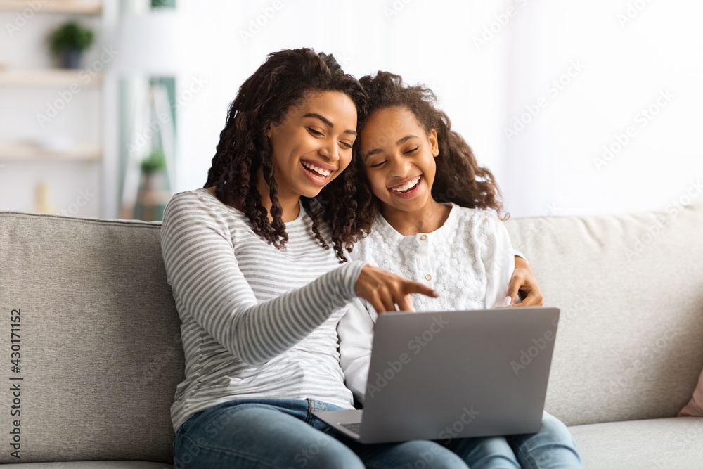 Excited african american mother and kid using laptop together Excited african american mother and kid using laptop together